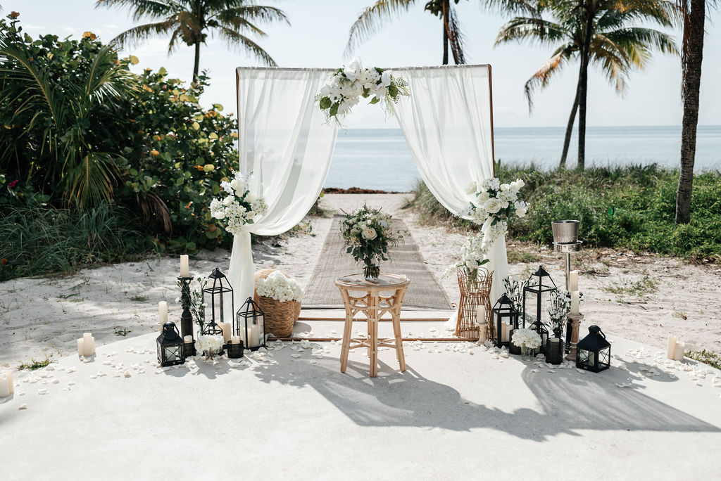 Beautiful beach ceremony setup with arch and palm trees