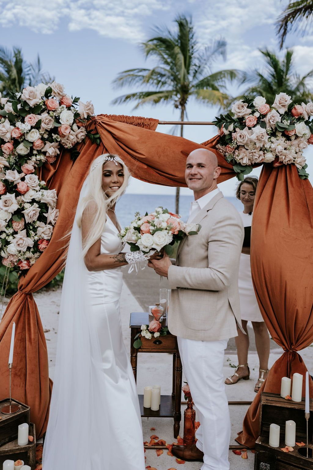 Couple smiling at the ceremony arch with ocean backdrop